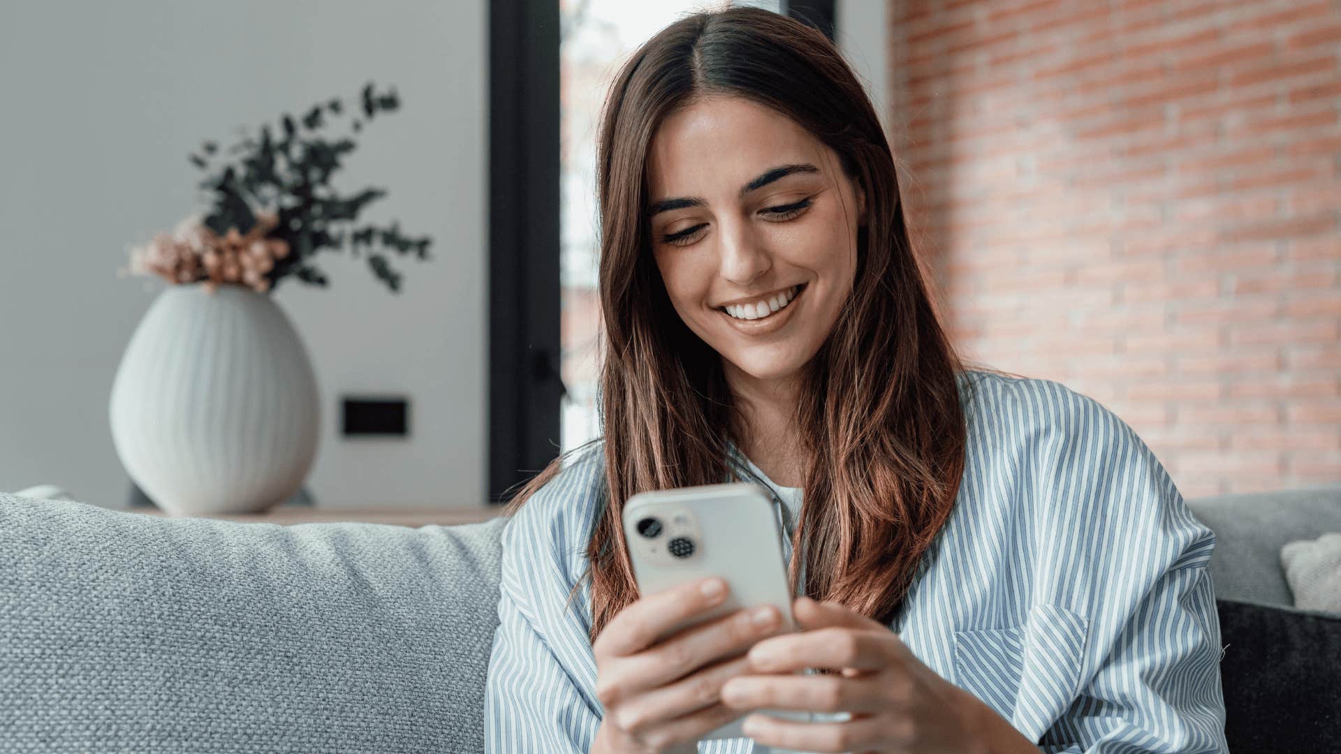 smiling woman who is an unforgettable parent to her kids looking at phone