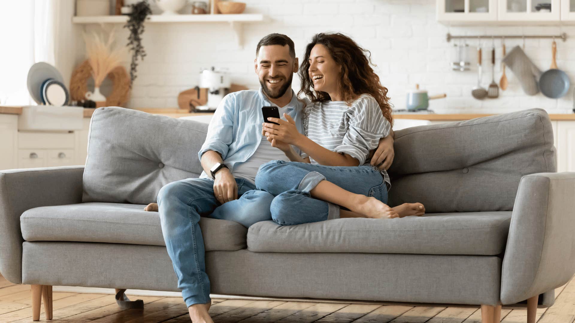 smiling impressive woman showing man her phone
