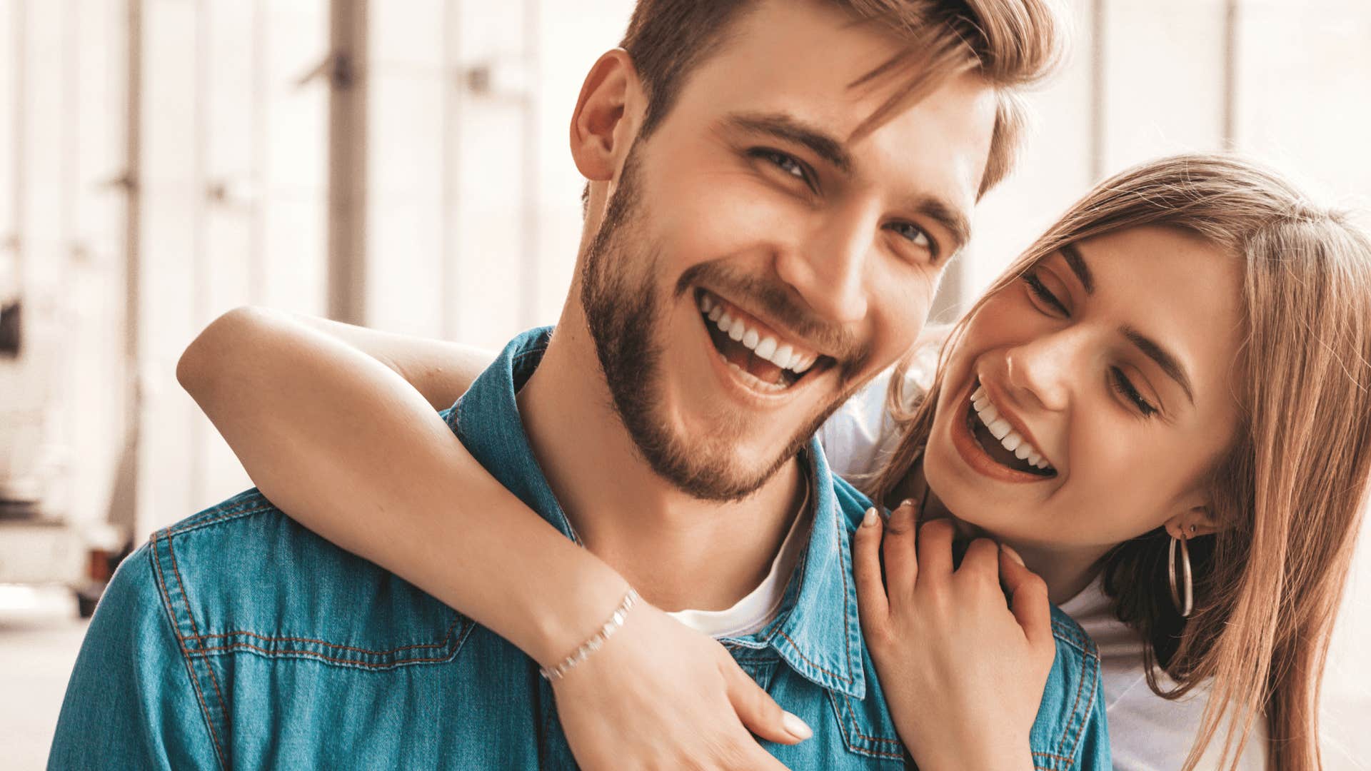 smiling woman hugging man as enviable couple
