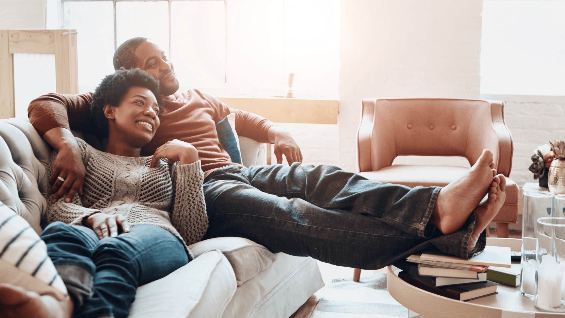 enviable couple cuddling on couch