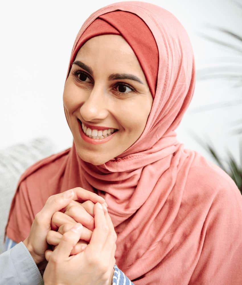 Joyful woman holds hands for better future
