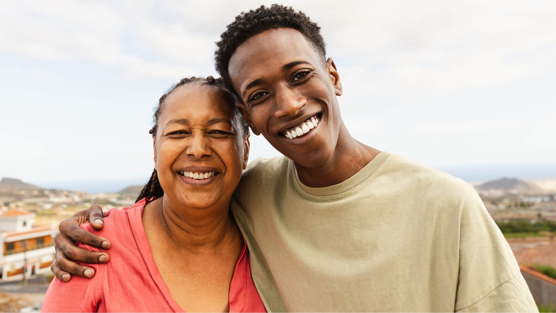 young man visiting hugging mom after coming home