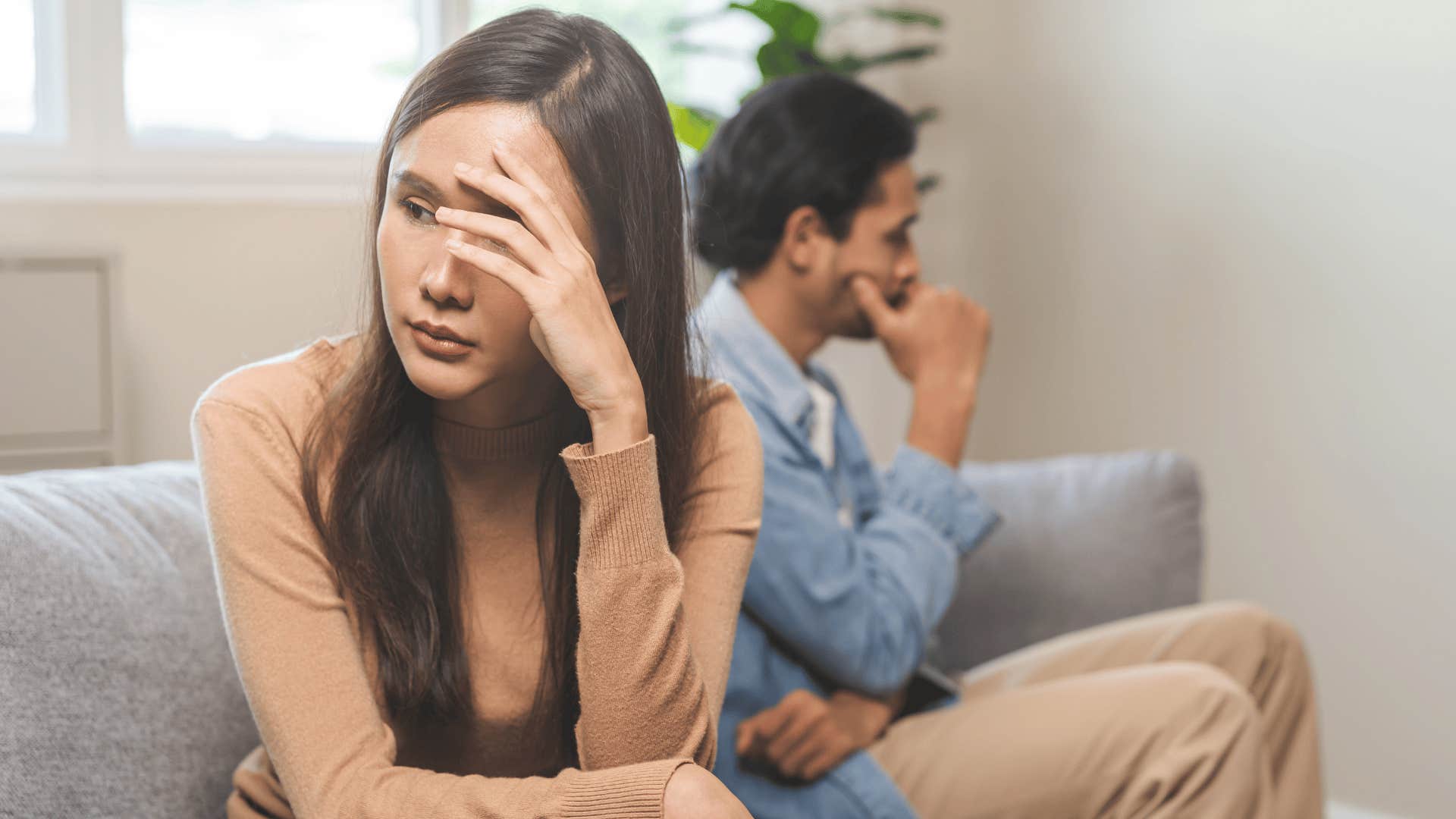 upset woman sitting next to man who would never think about cheating