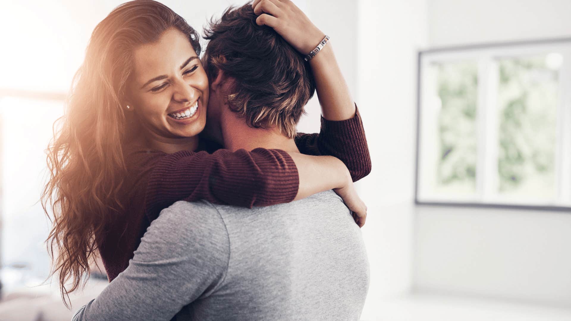 laughing woman hugging man who would never cheat on her