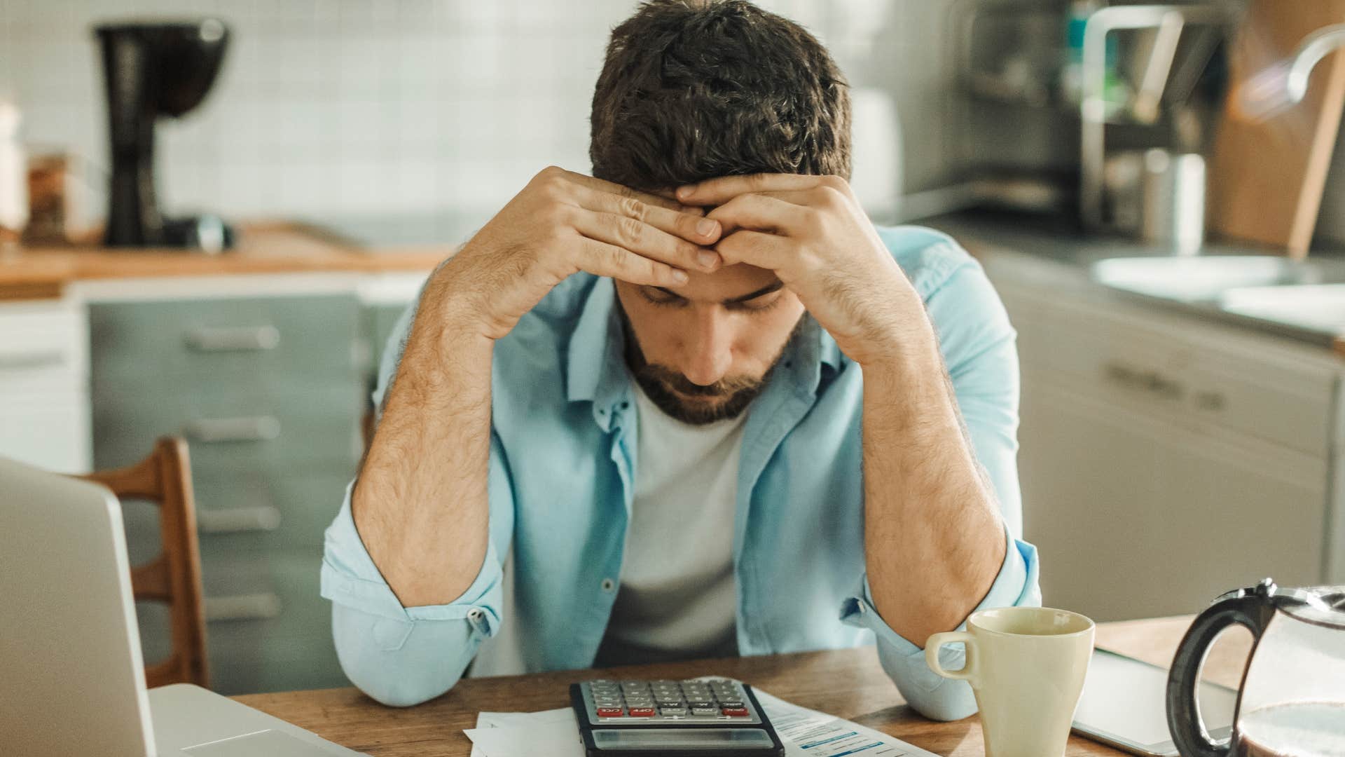 stressed man looking at his bills unable to afford to pay