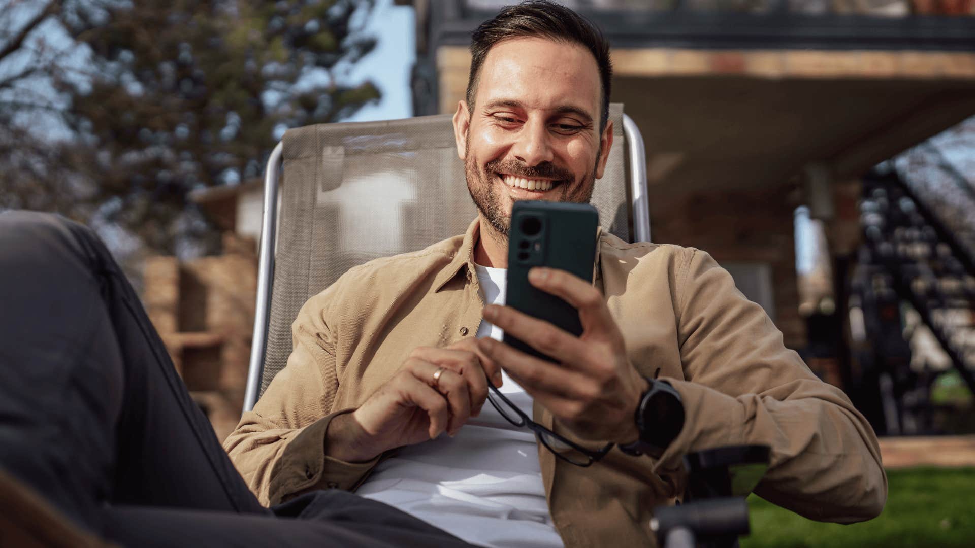 Man prioritizes listening over speaking as he's texting while sitting outside his house