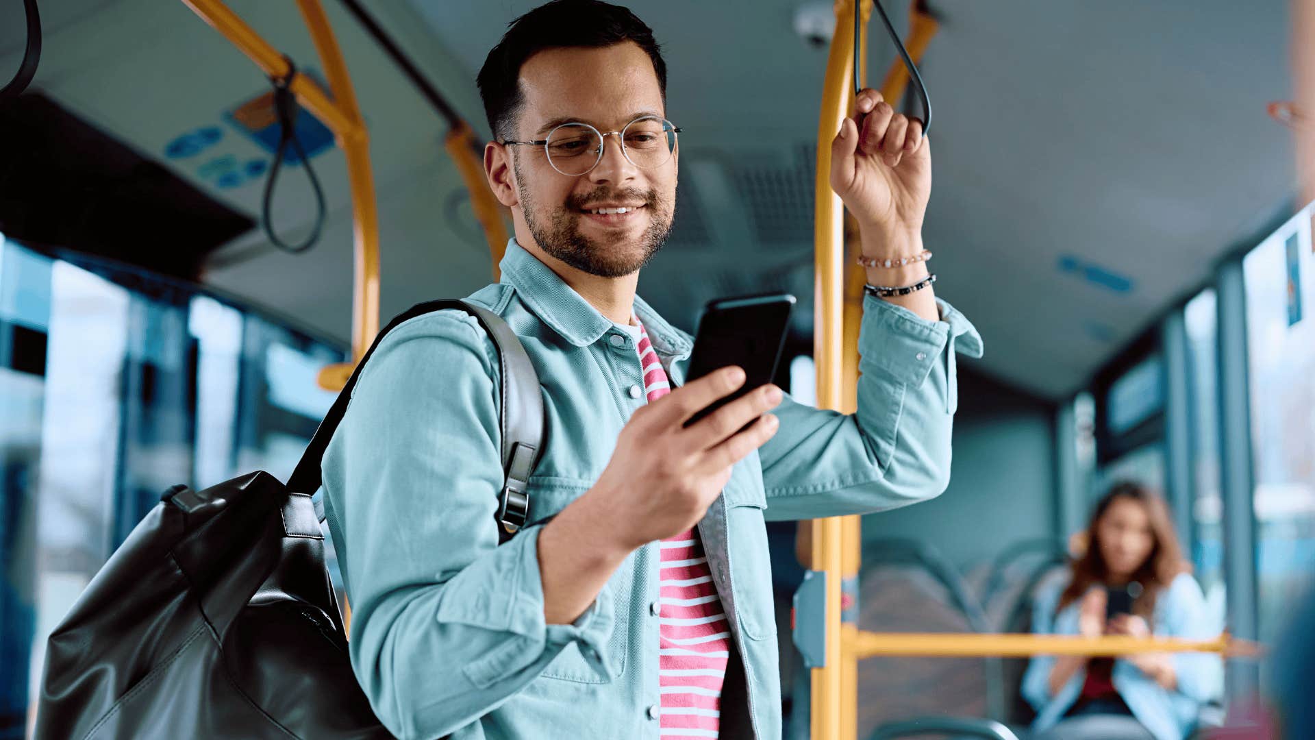 Man sees every message when looking at his phone on the bus