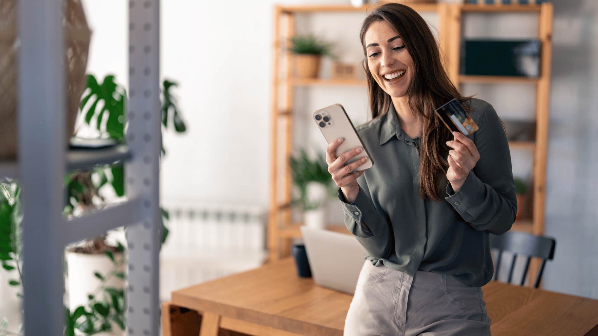 woman in dark shirt being financially irresponsible as she shops online with card