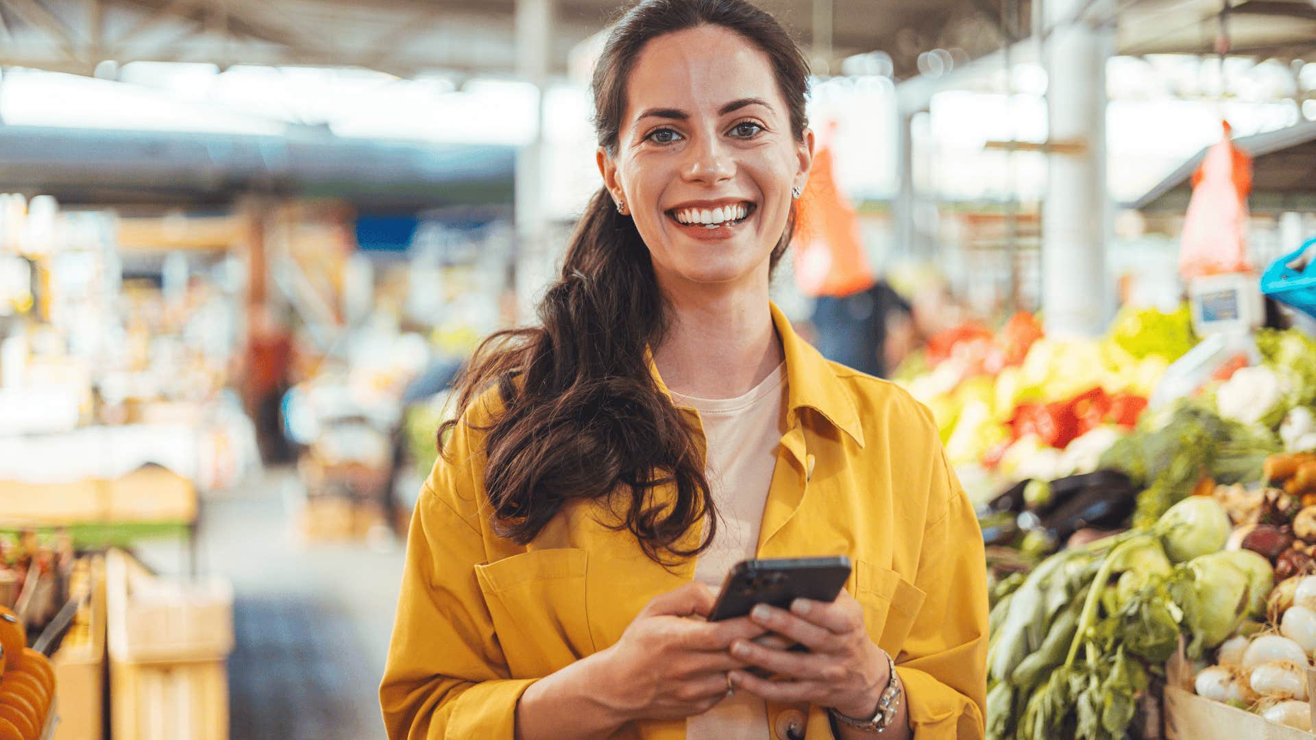 happy woman texting at the grocery store