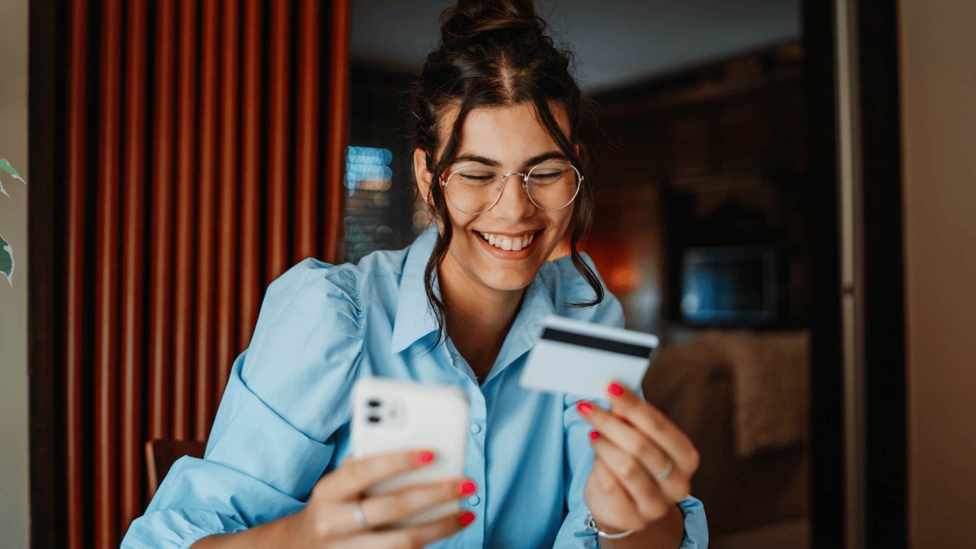 woman smiling while holding her credit card