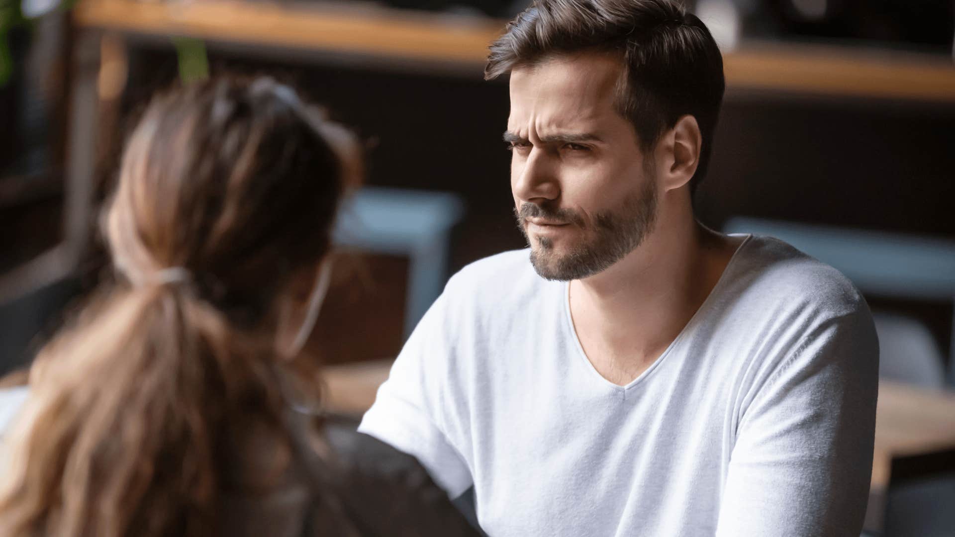 confused man talking to woman who is really hard to love