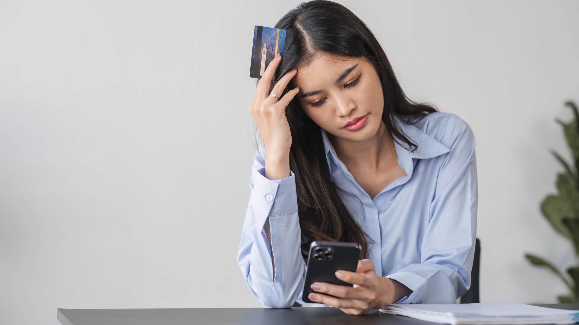 stressed gen z woman paying off debt with credit card
