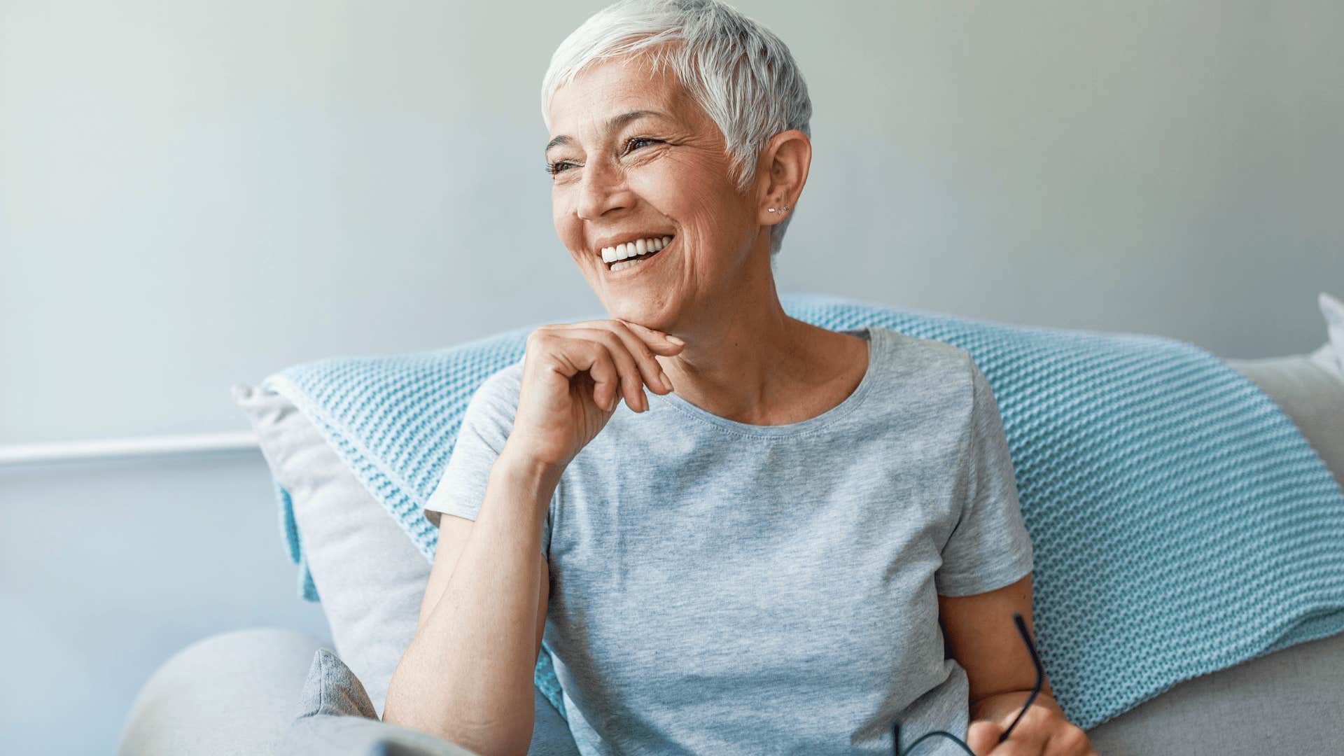 older woman smiling looking out the window