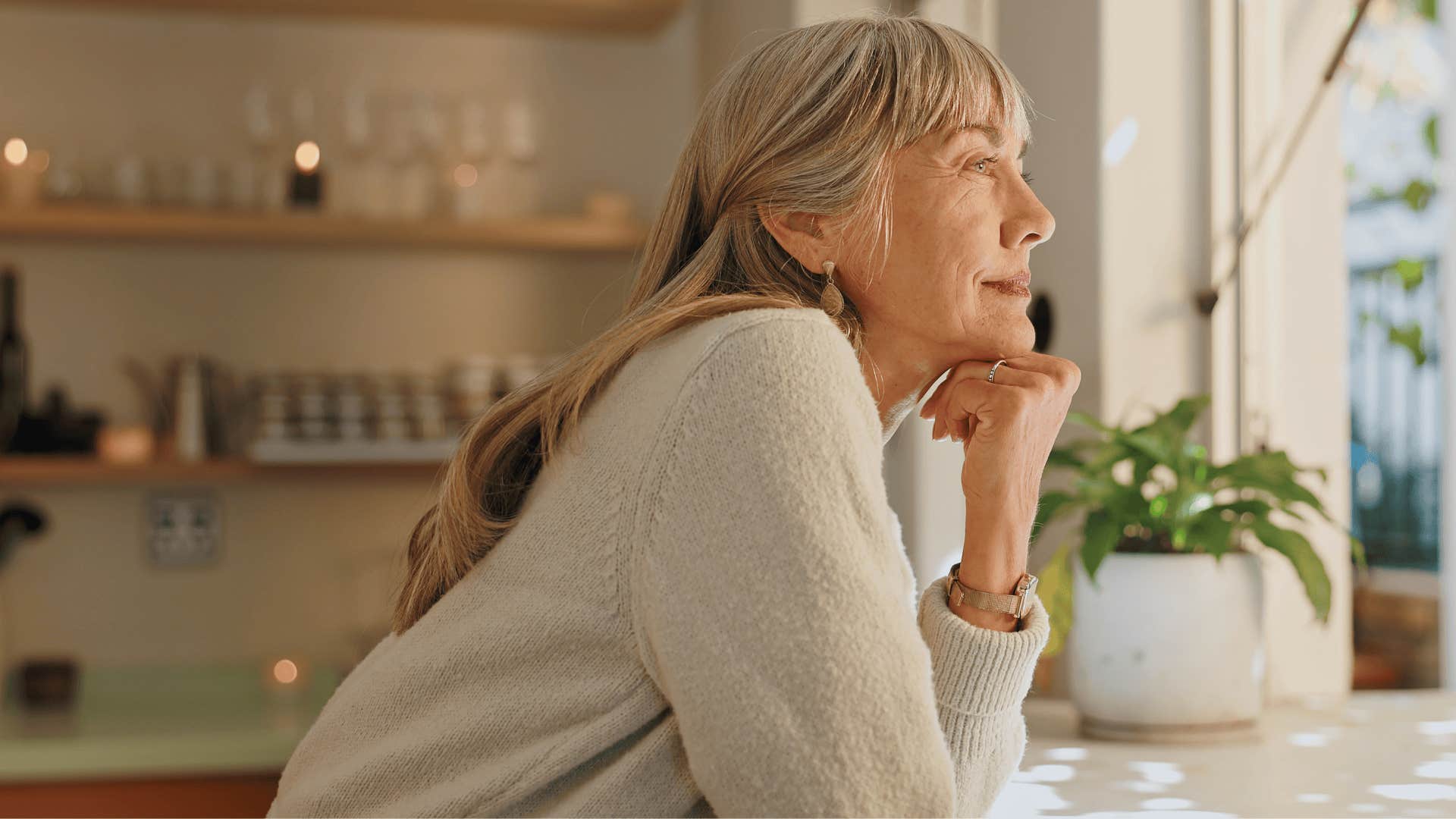 older woman smiling contently in her kitchen