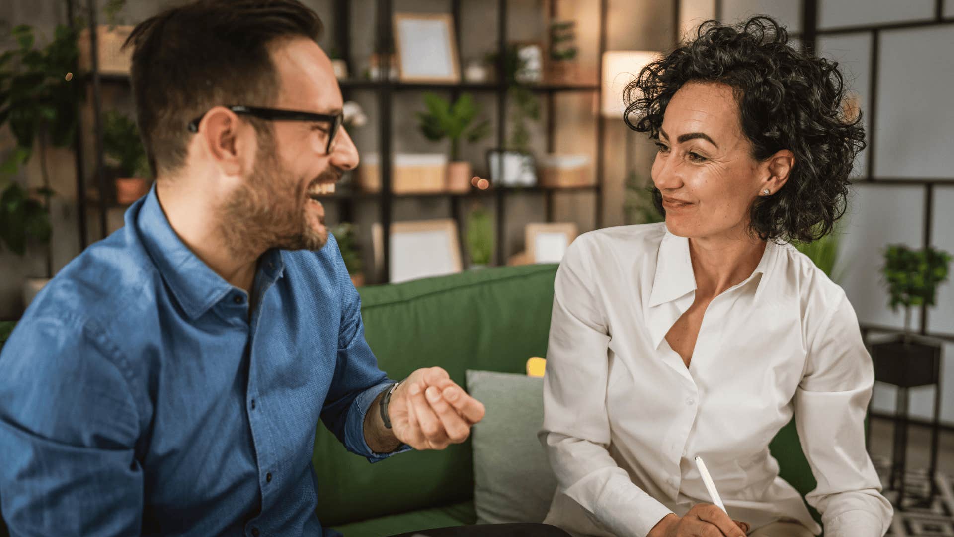 couple smiling and talking on their couch