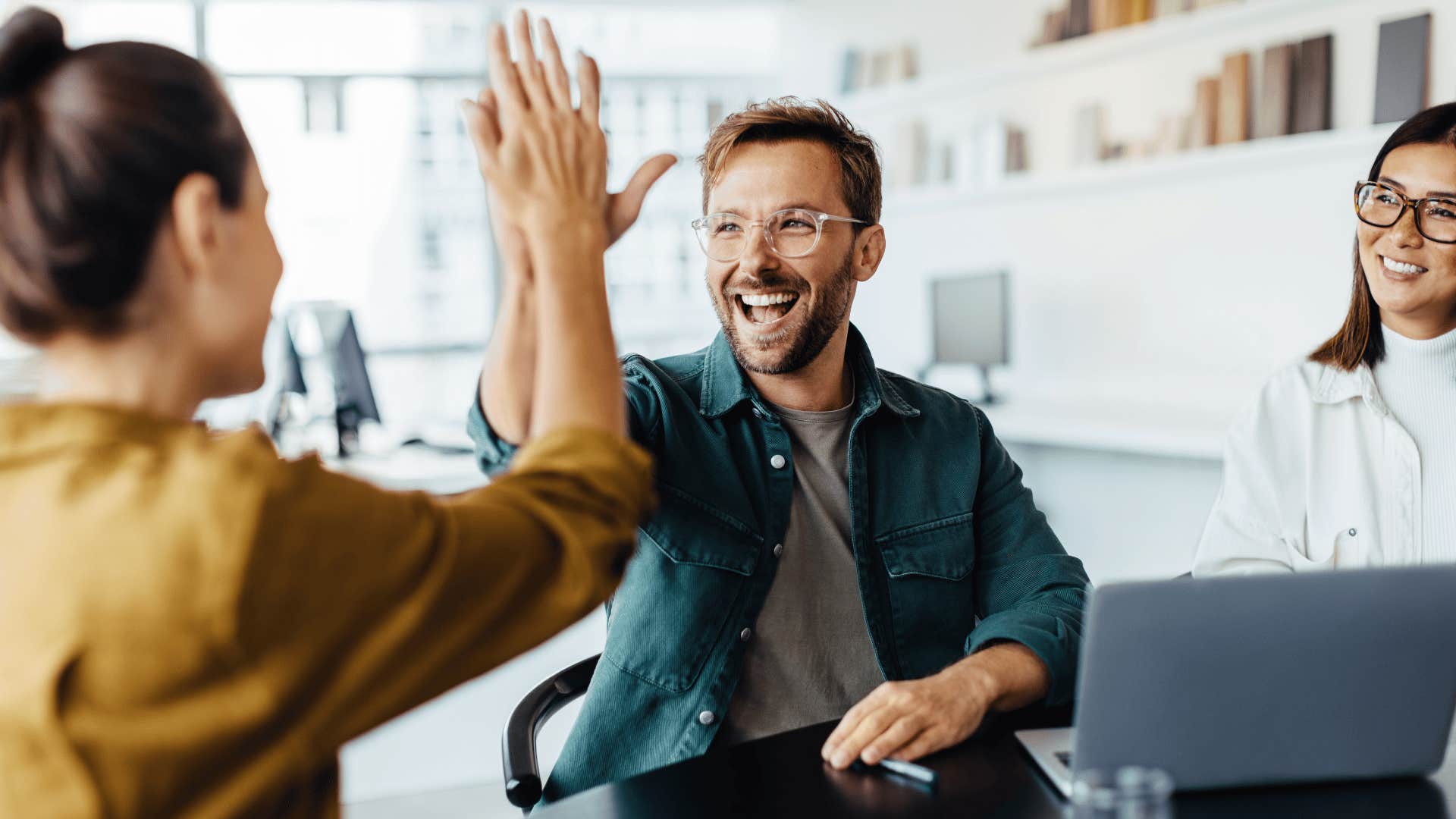 man celebrating co-worker giving her a high five