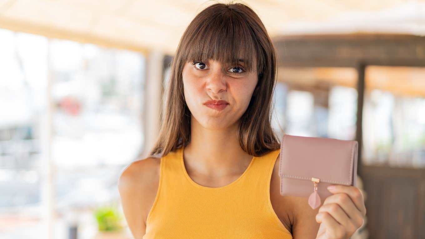 stressed gen z woman holding her wallet