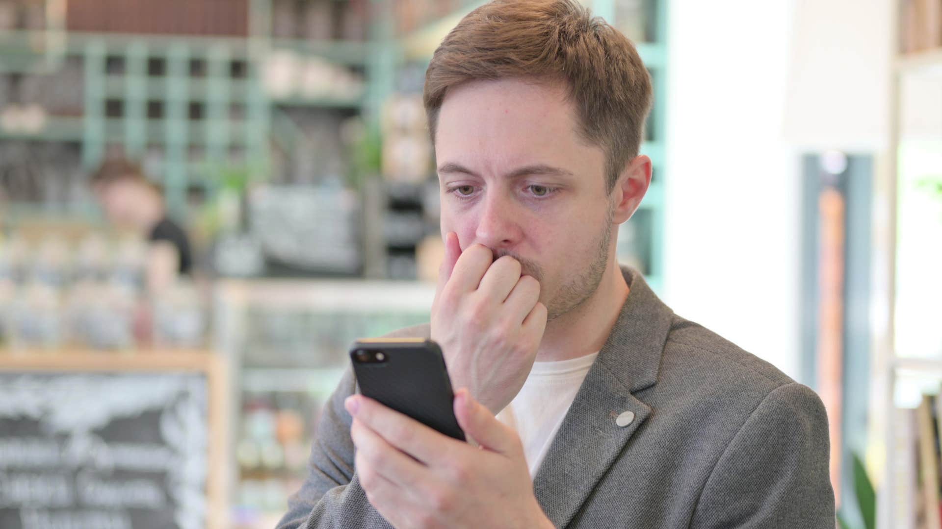 anxious man looking at credit score on his phone
