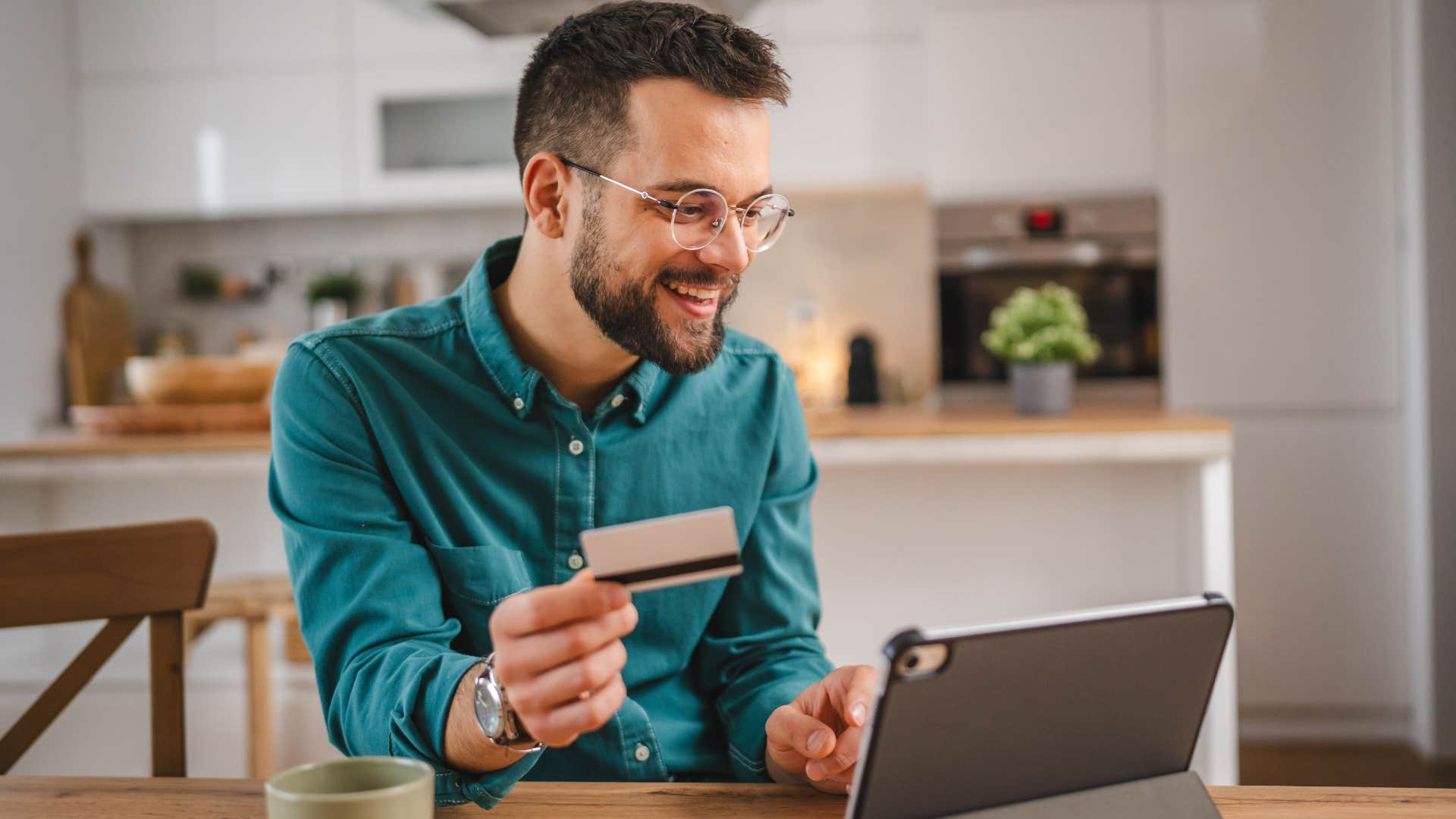happy gen z man spending on little luxuries with his credit card
