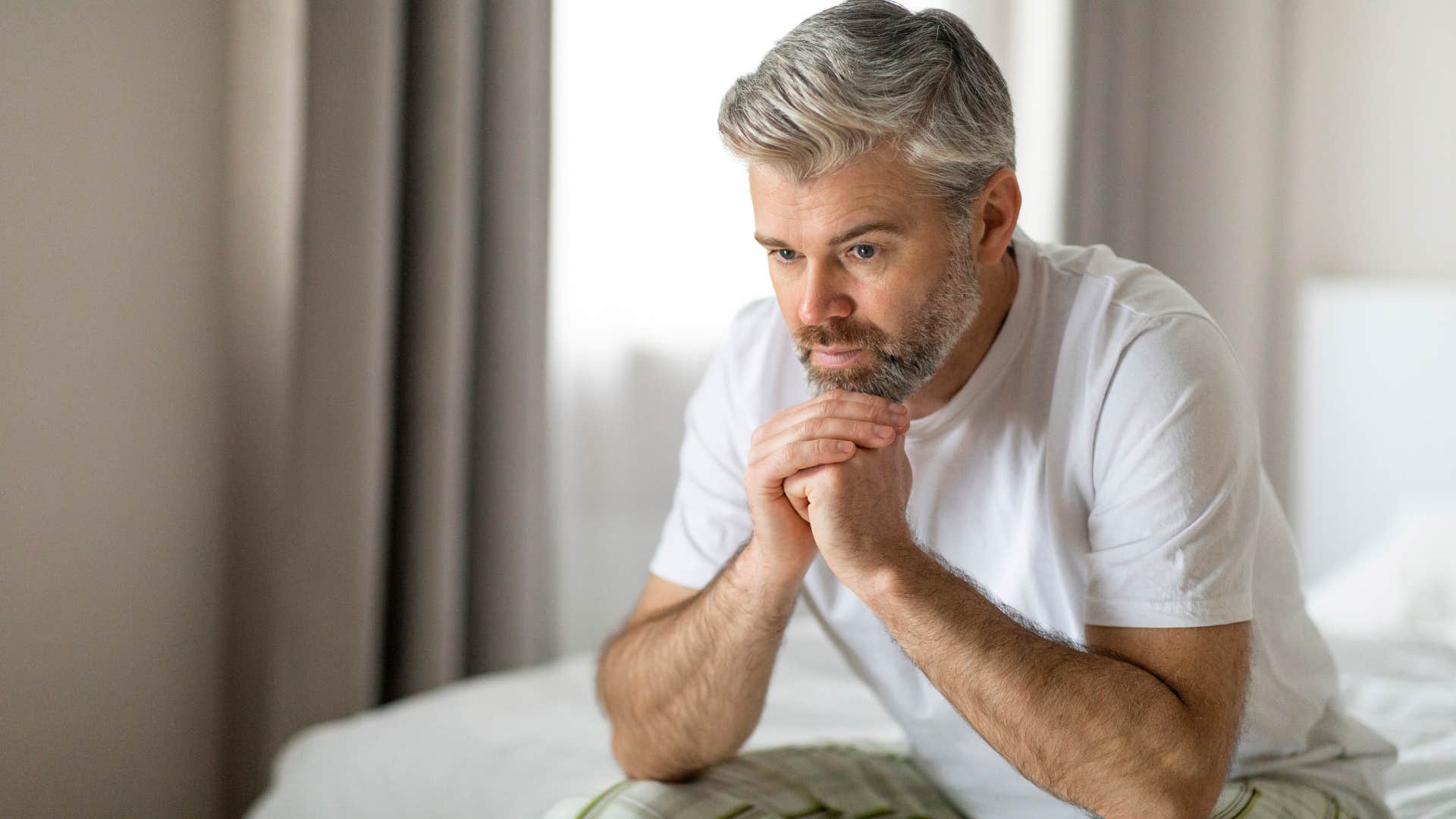 man with no future plans holding his head in his hands