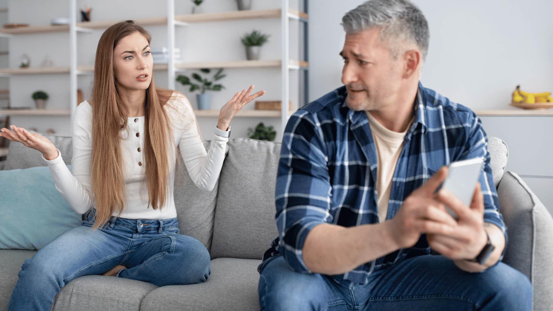 A husband avoids conflict with his wife by being on his phone.