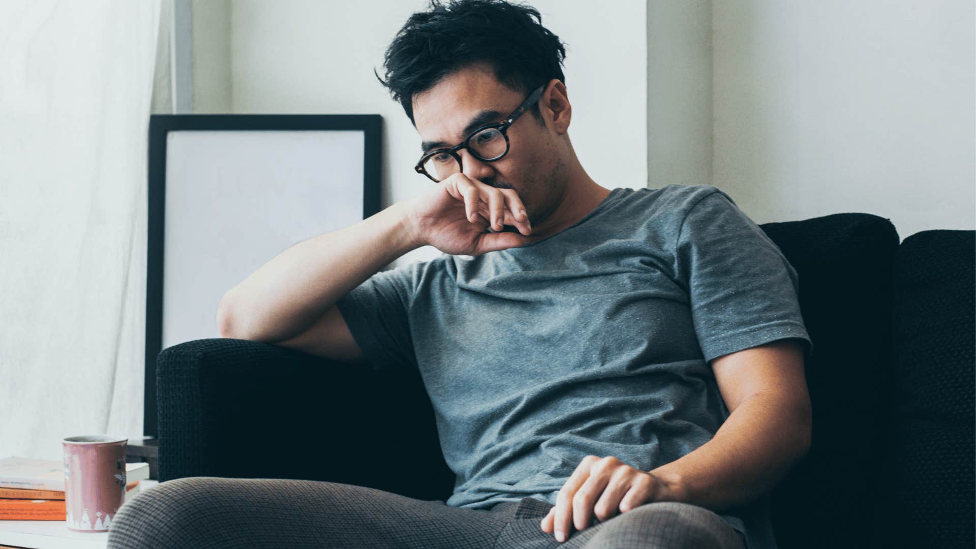 A man sits as he shows signs of a fear of failure.