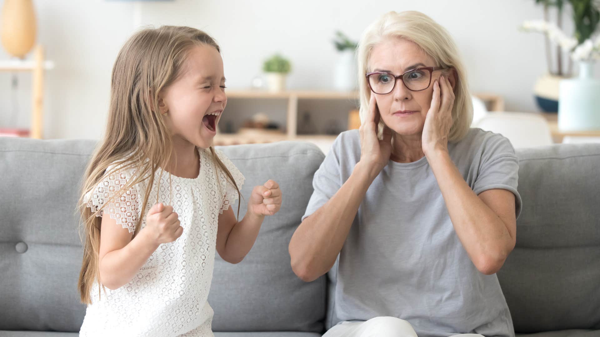older woman covering her ears as a child makes noise