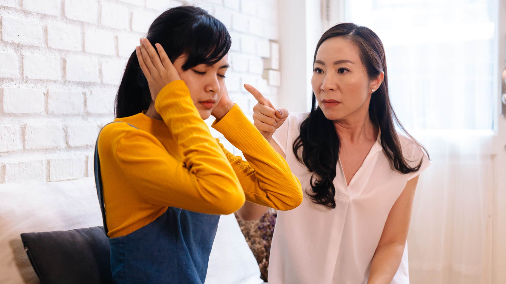 young woman covering her ears trying to avoid communication