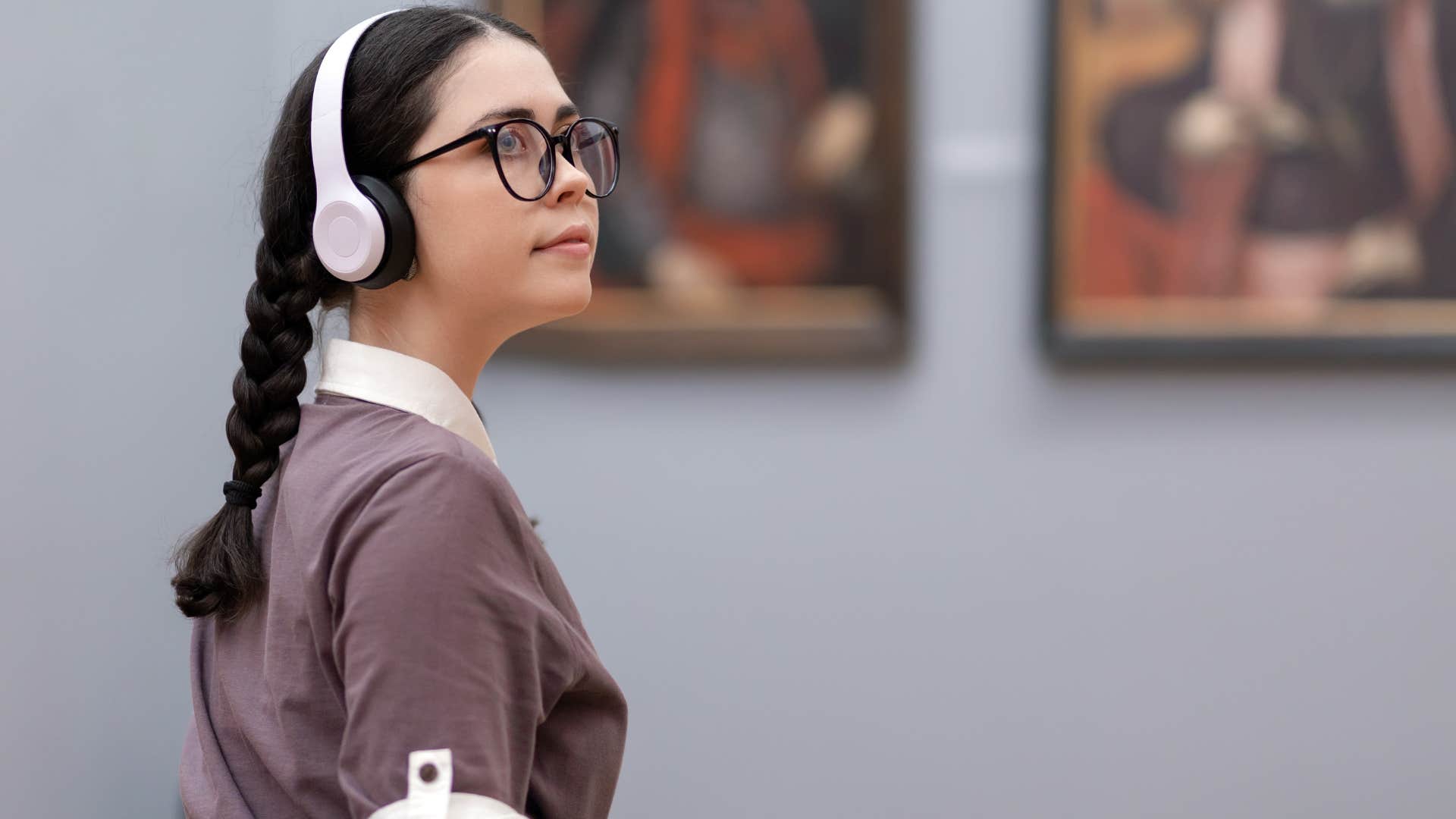 young woman wearing headphones in an art gallery to drown out noise