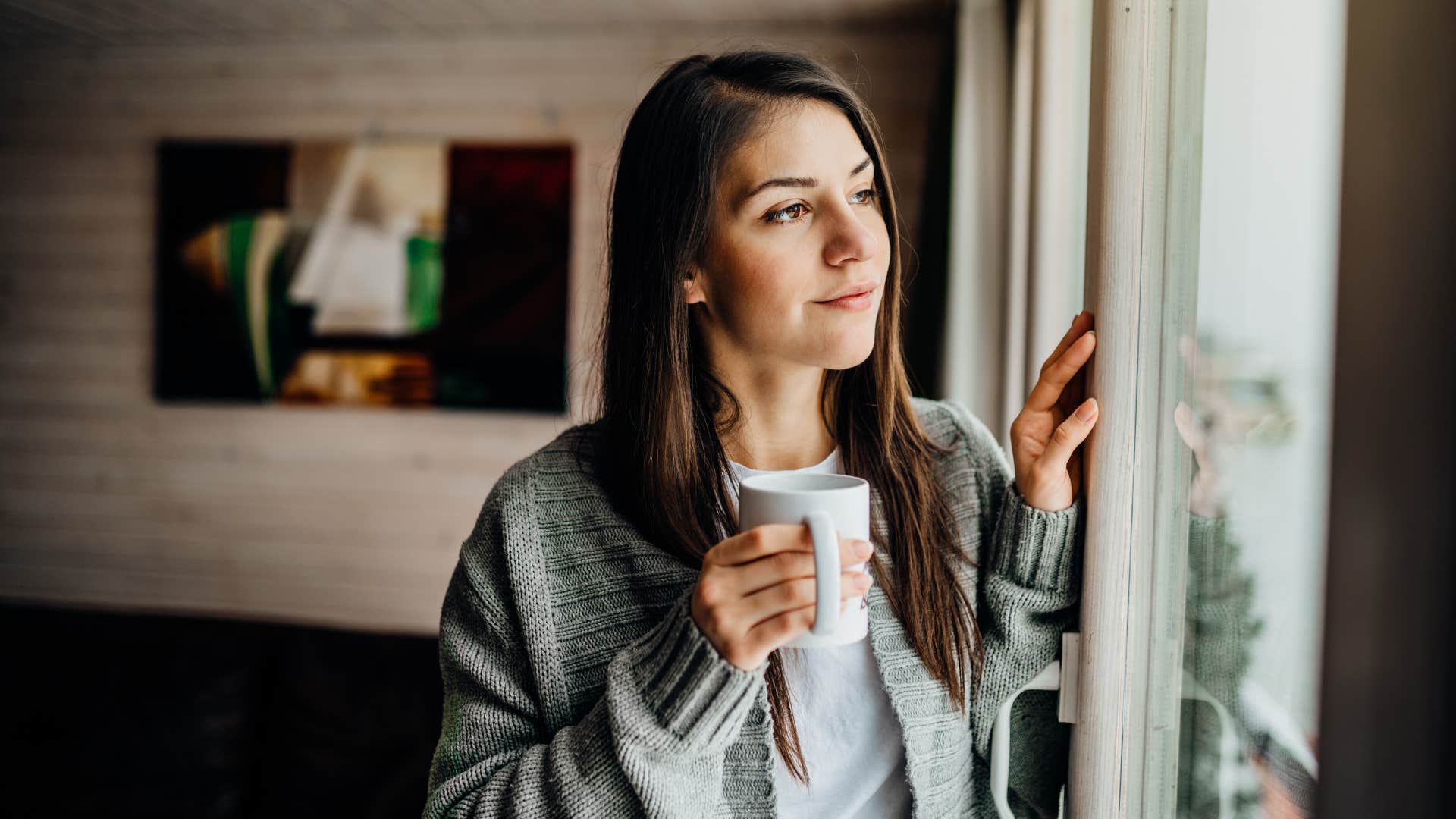 woman with coffee isolating herself looking outside