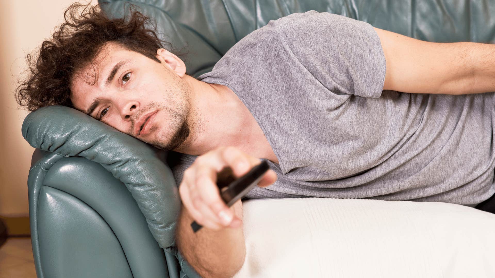 husband lays on the couch while he neglects his appearance and health