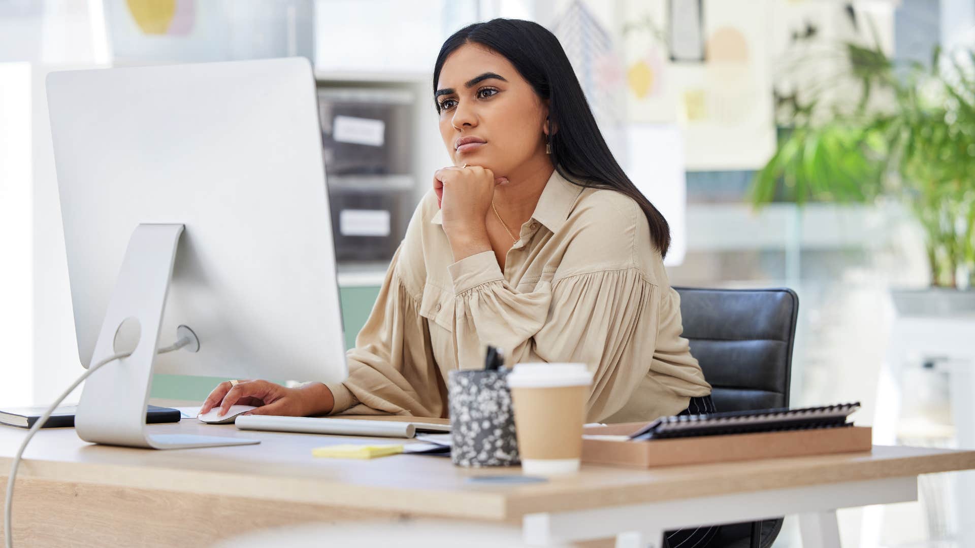 woman reading emails at work looking stressed