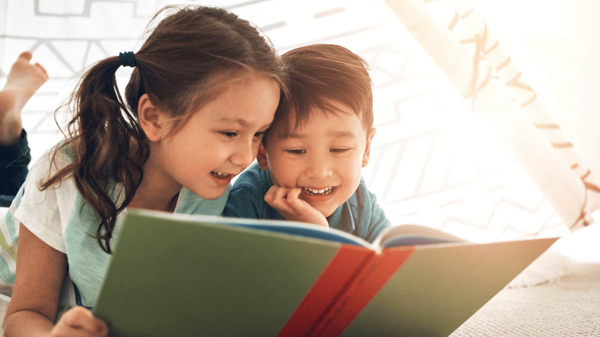 Sister shares book with little brother