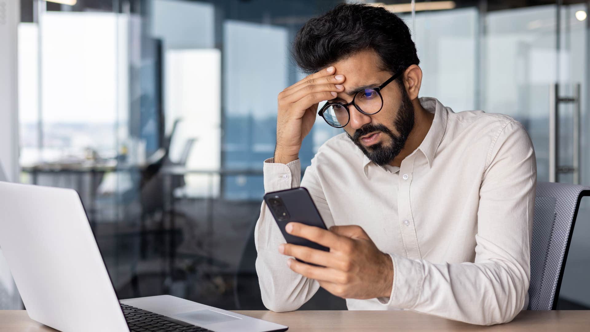 stressed man struggling to make a doctors appointment on his phone