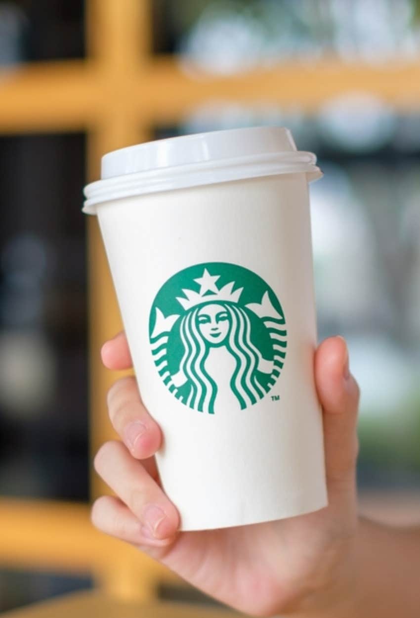 customer holding coffee after being informed of Starbucks Code of Conduct