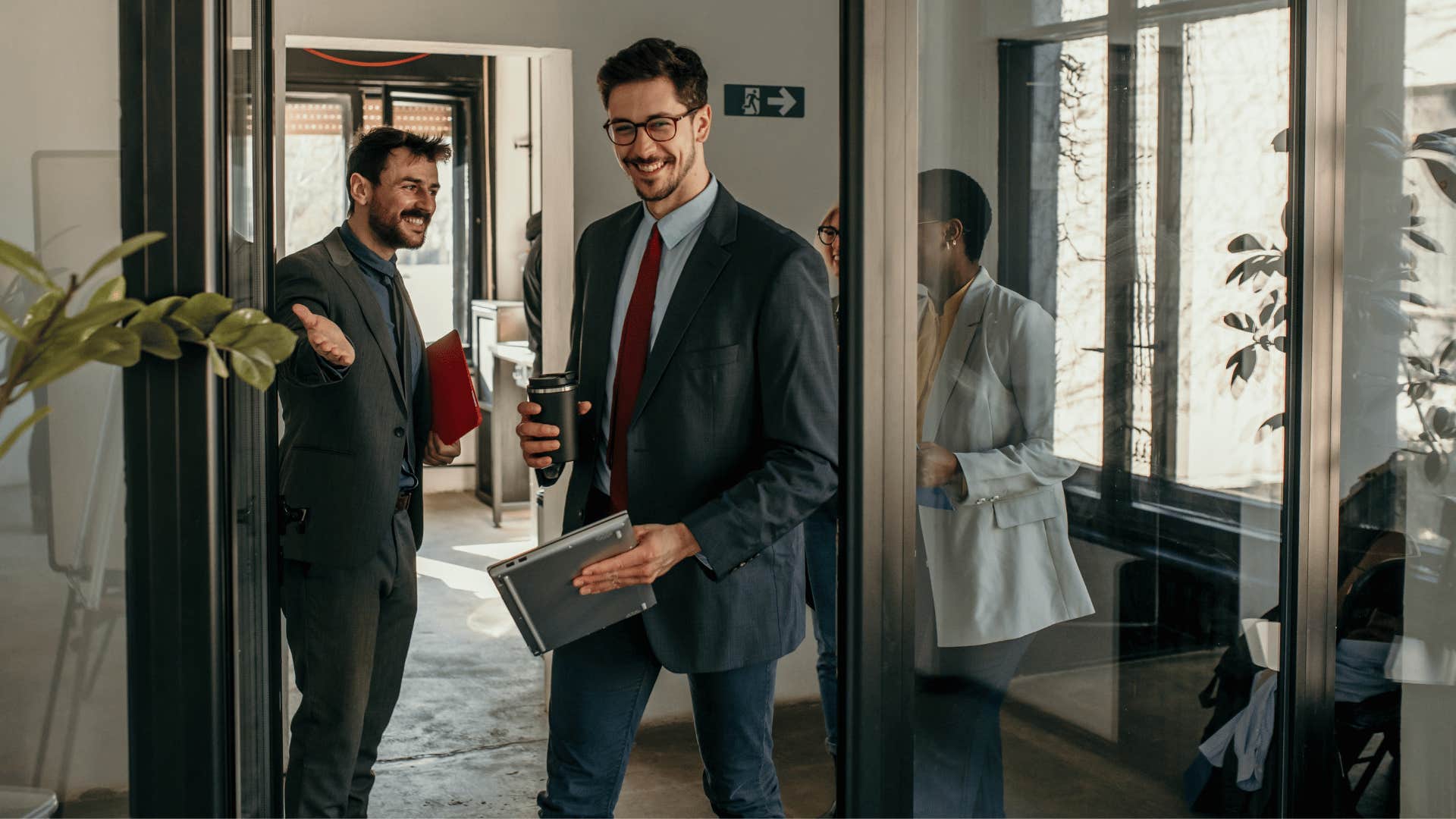 man holding door open while other man refuses to say thank you