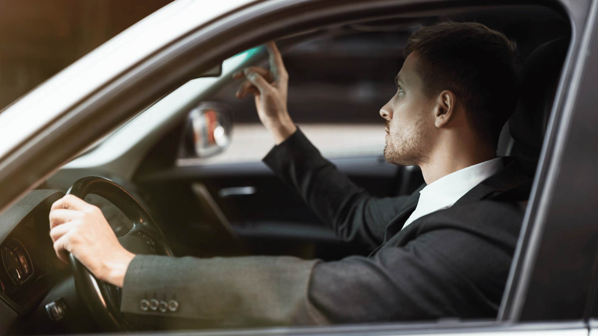 man adjusting rear view mirror not turning high beams off