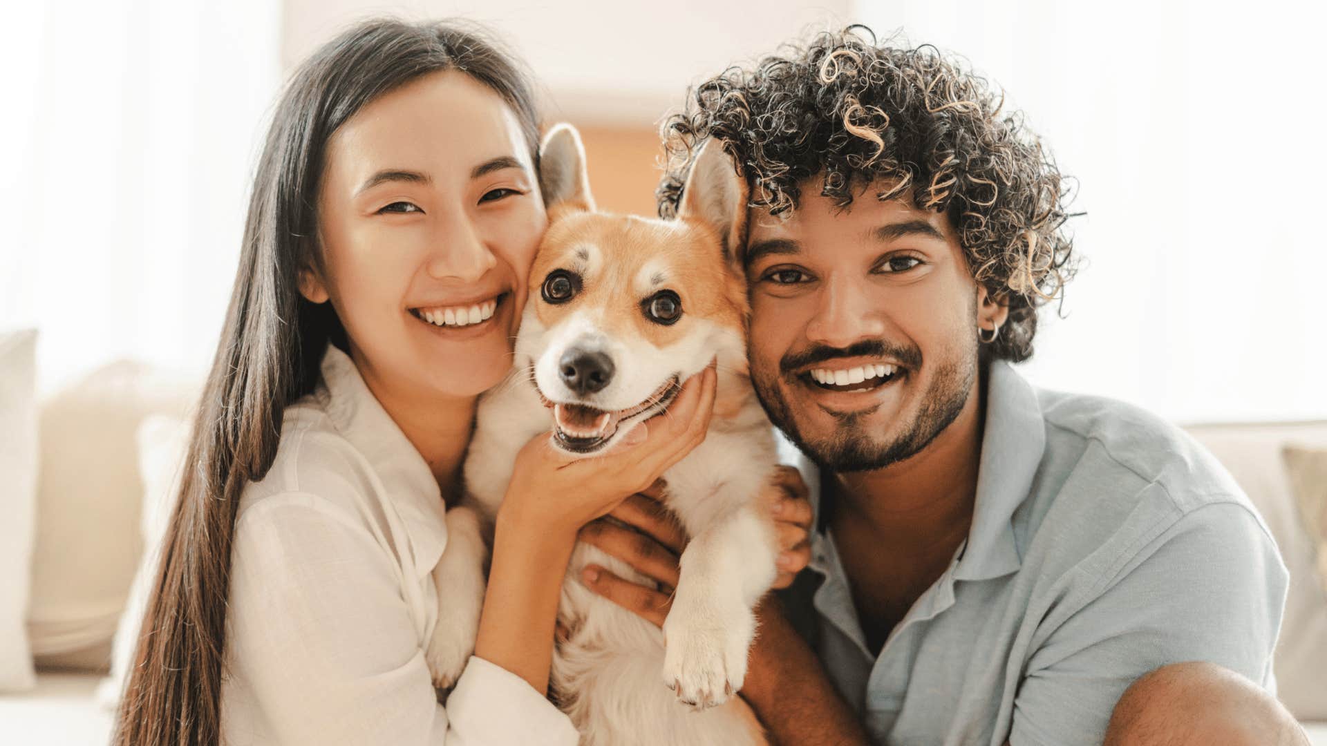 millennial couple hugging their dog