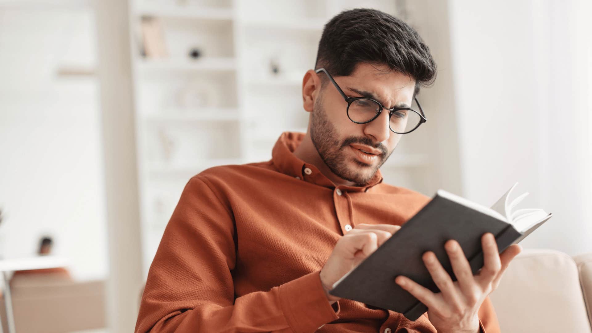 millennial man reading a book to learn