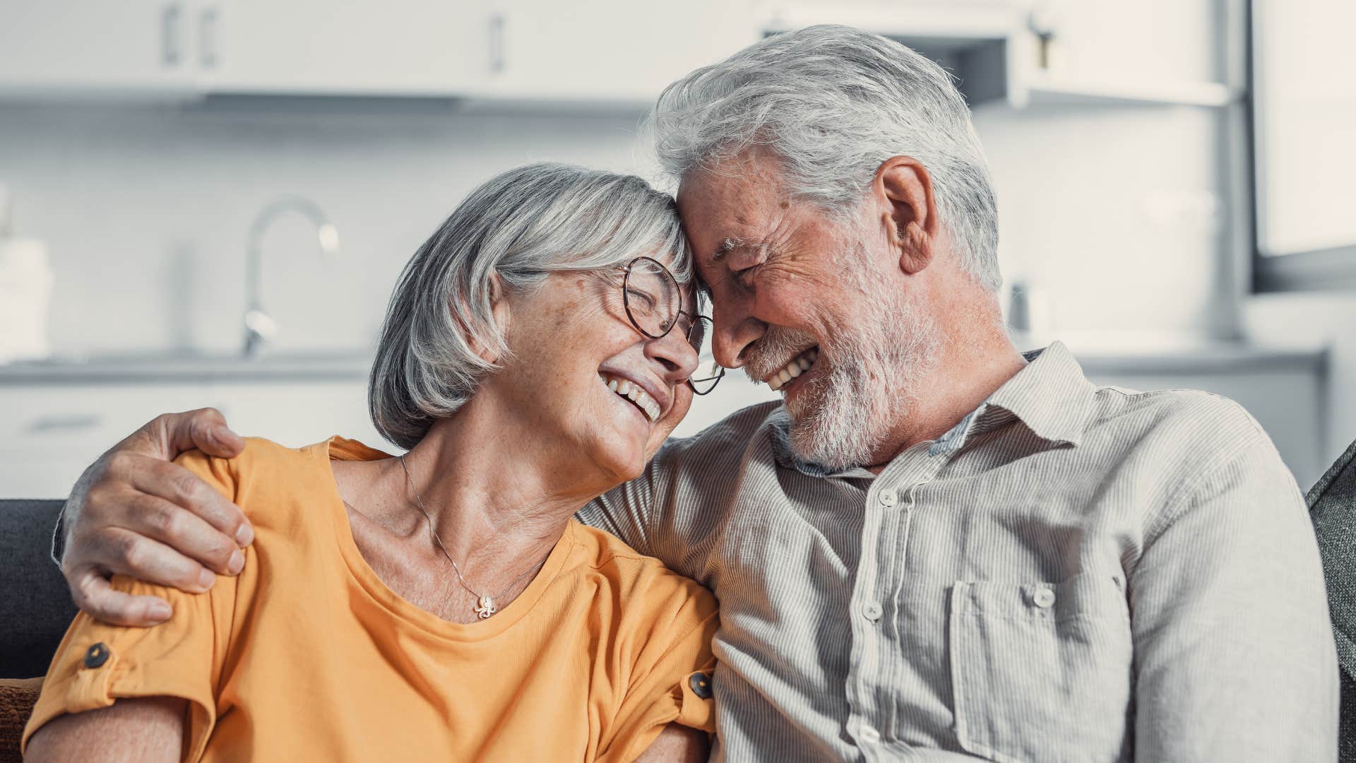 Baby boomer couple finding joy in the little things while hugging each other.