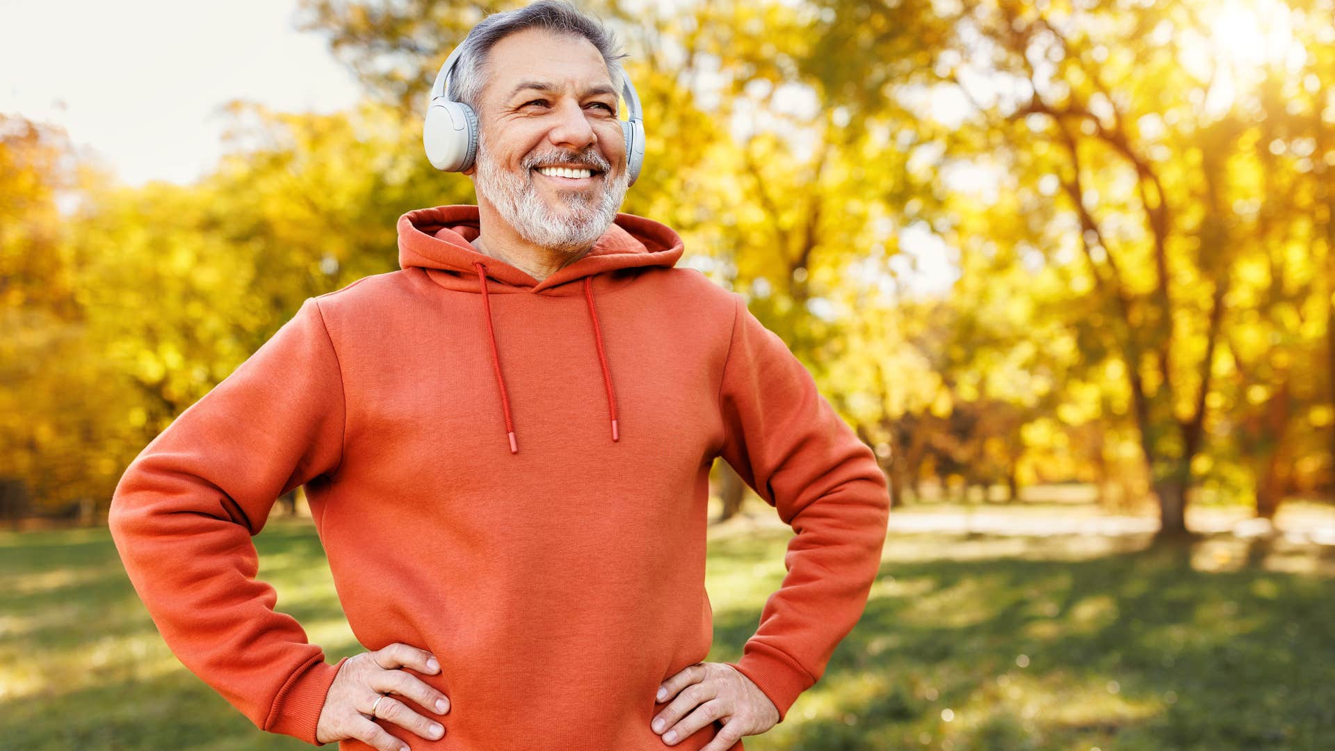 Man building a routine smiling outside with headphones on.