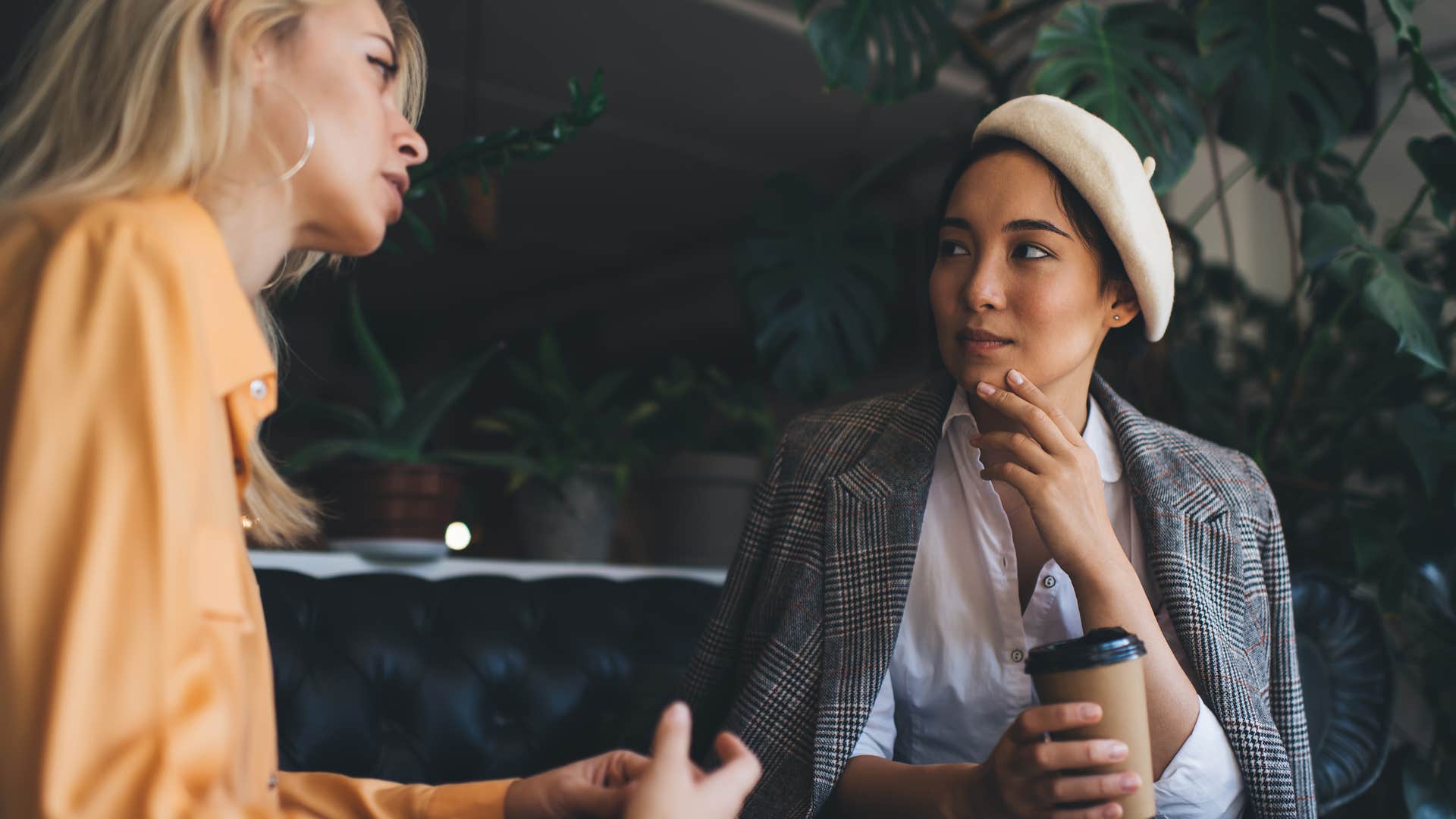 woman who doesn't feel safe around friend looking uncomfortable as friend in yellow shirt talks