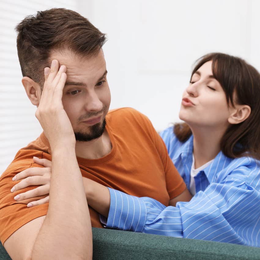 man who clearly doesn't want woman resisting kissing her