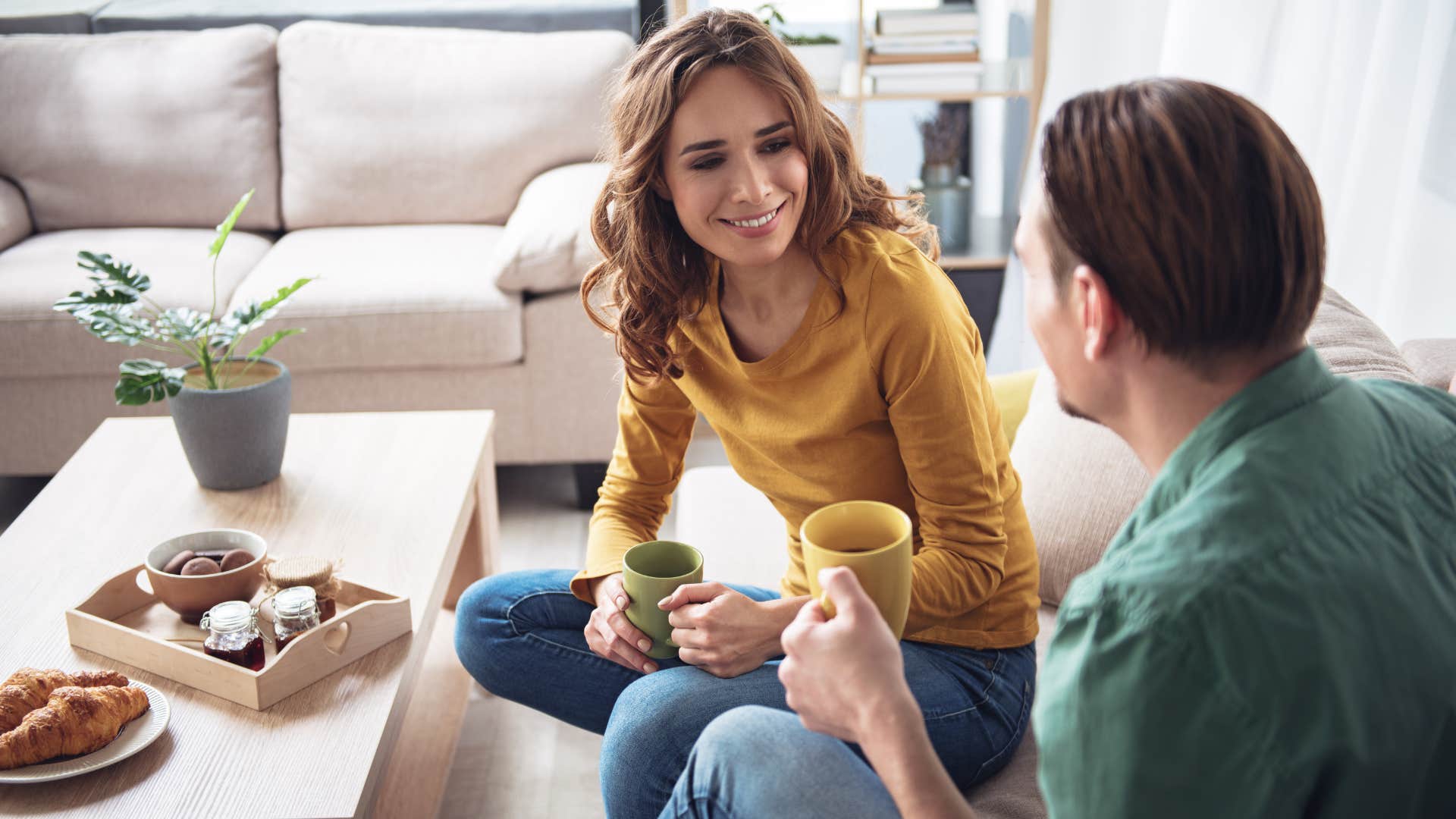 A couple drinks coffee as a wife offers emotional support to her husband