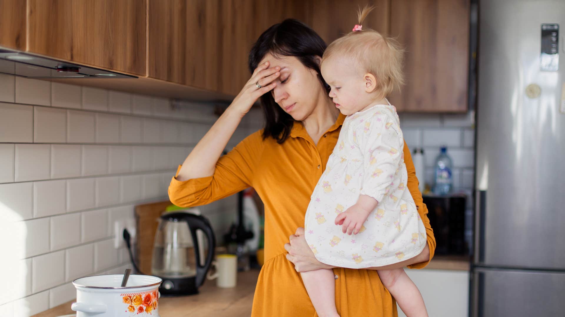A wife takes care of her daughter and cooks at the same time dealing with multiple roles