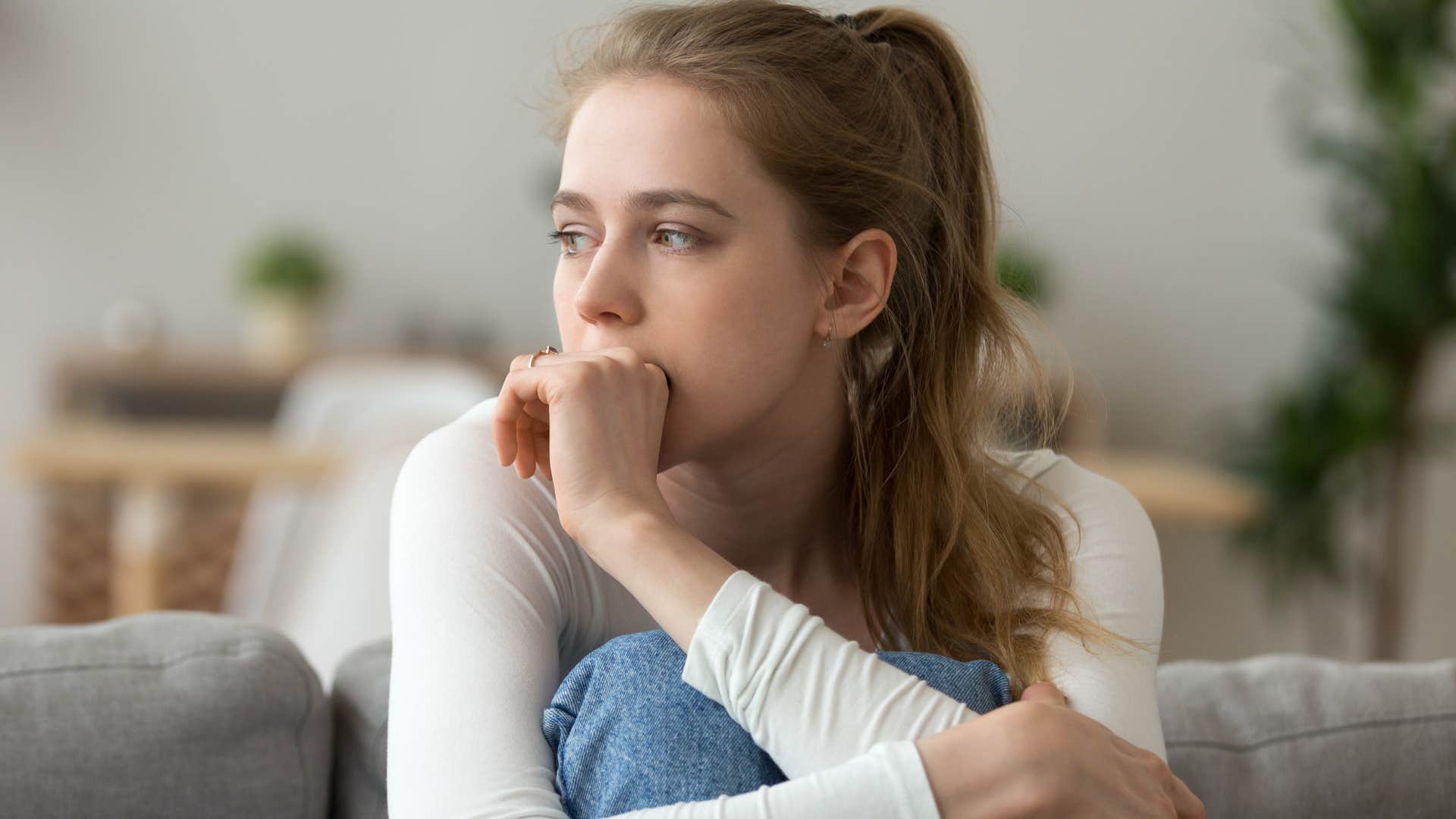 parentified teenage girl looking stressed on the couch