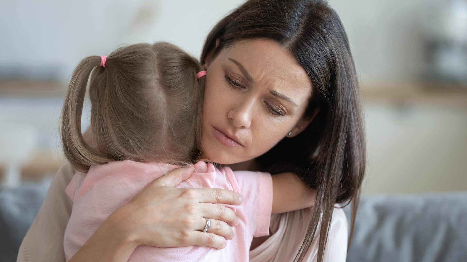 woman hugging young daughter upset about no babysitting help