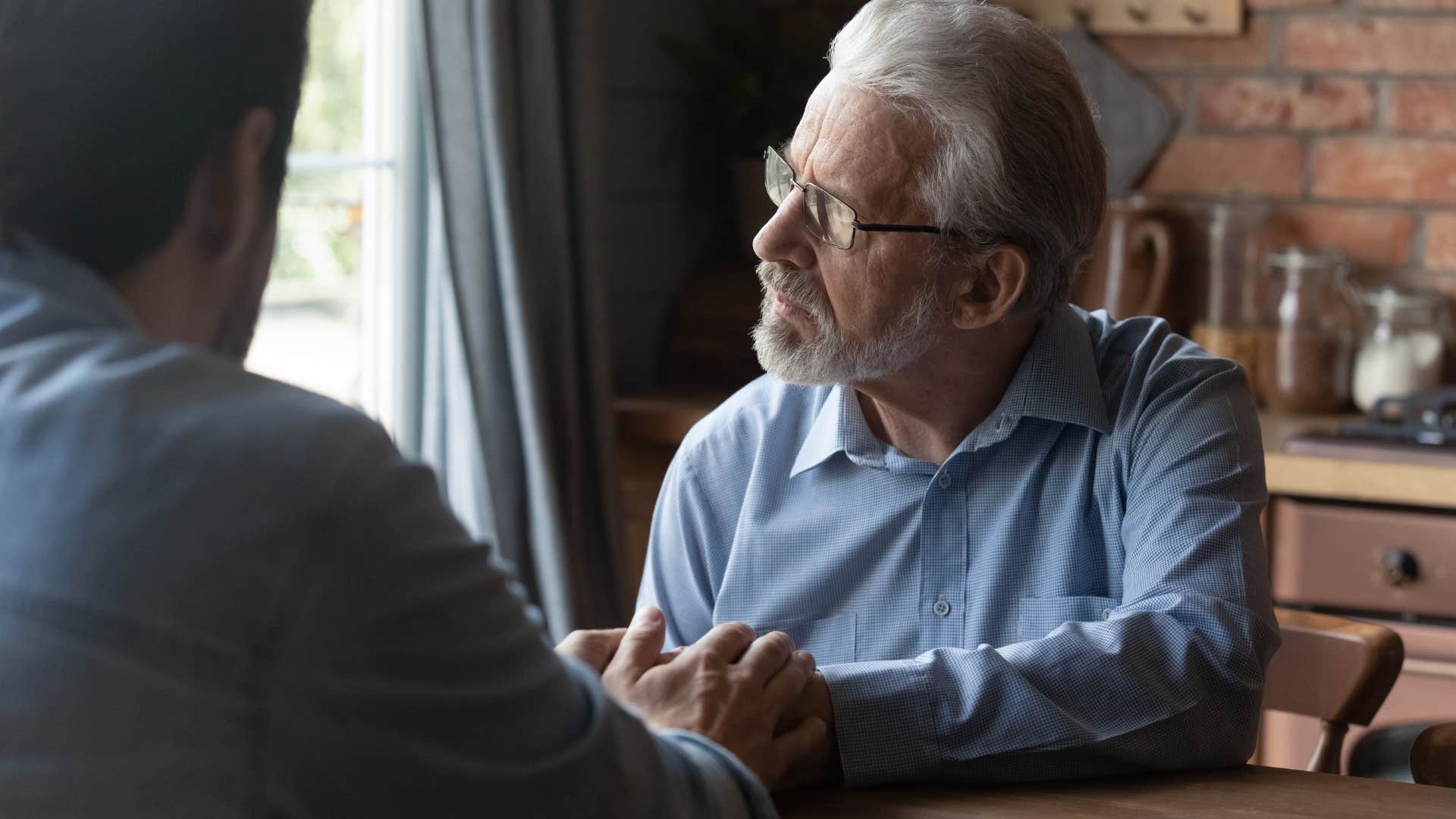 upset men holding his adult sons hand talking about financial support