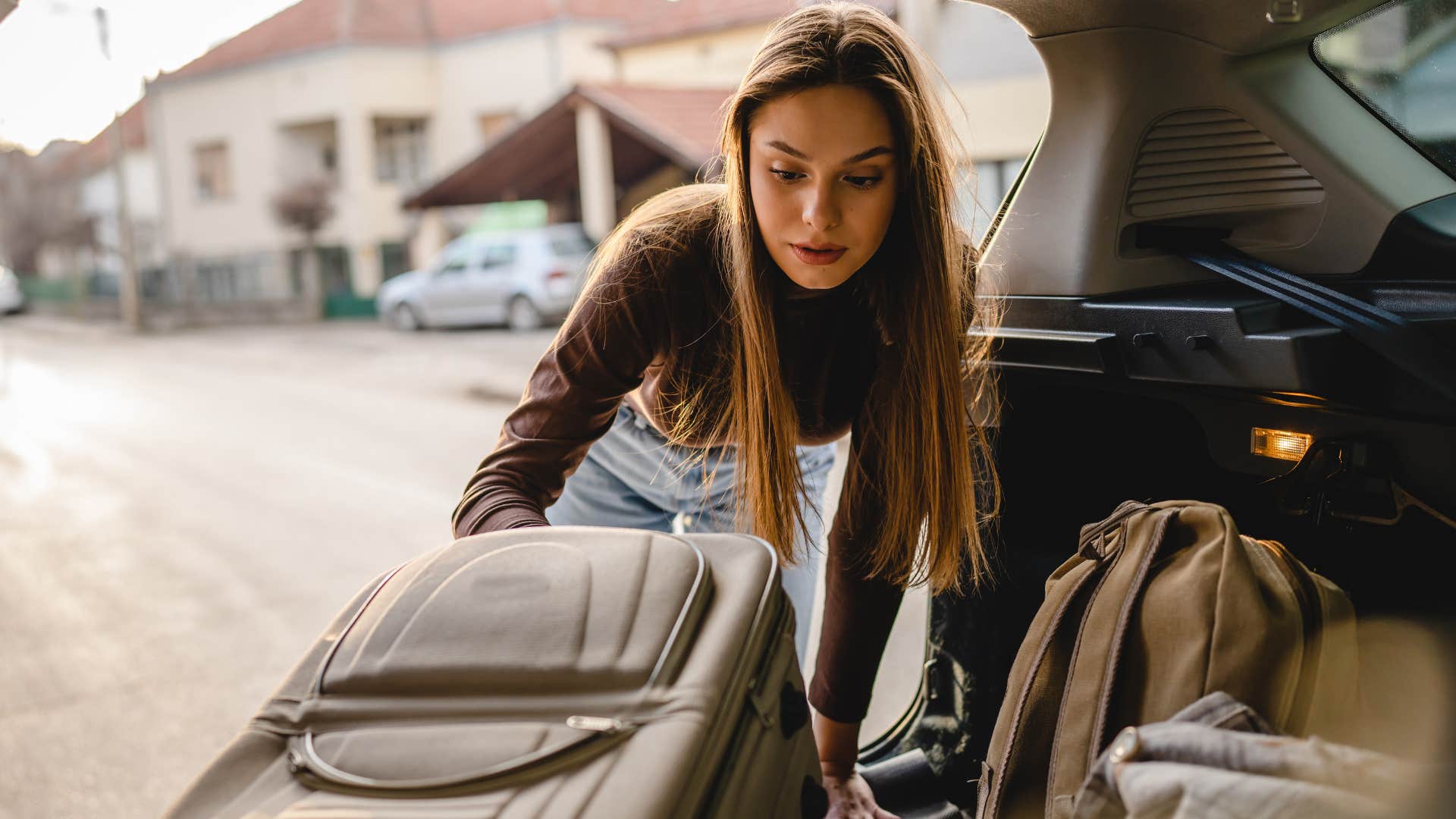 woman packing car for a vacation she can't afford