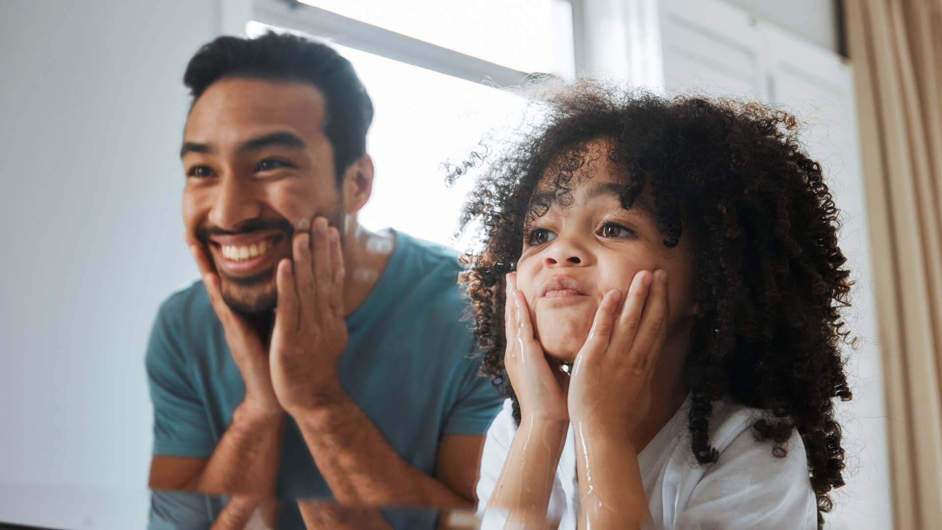 dad and daughter looking in mirror being silly